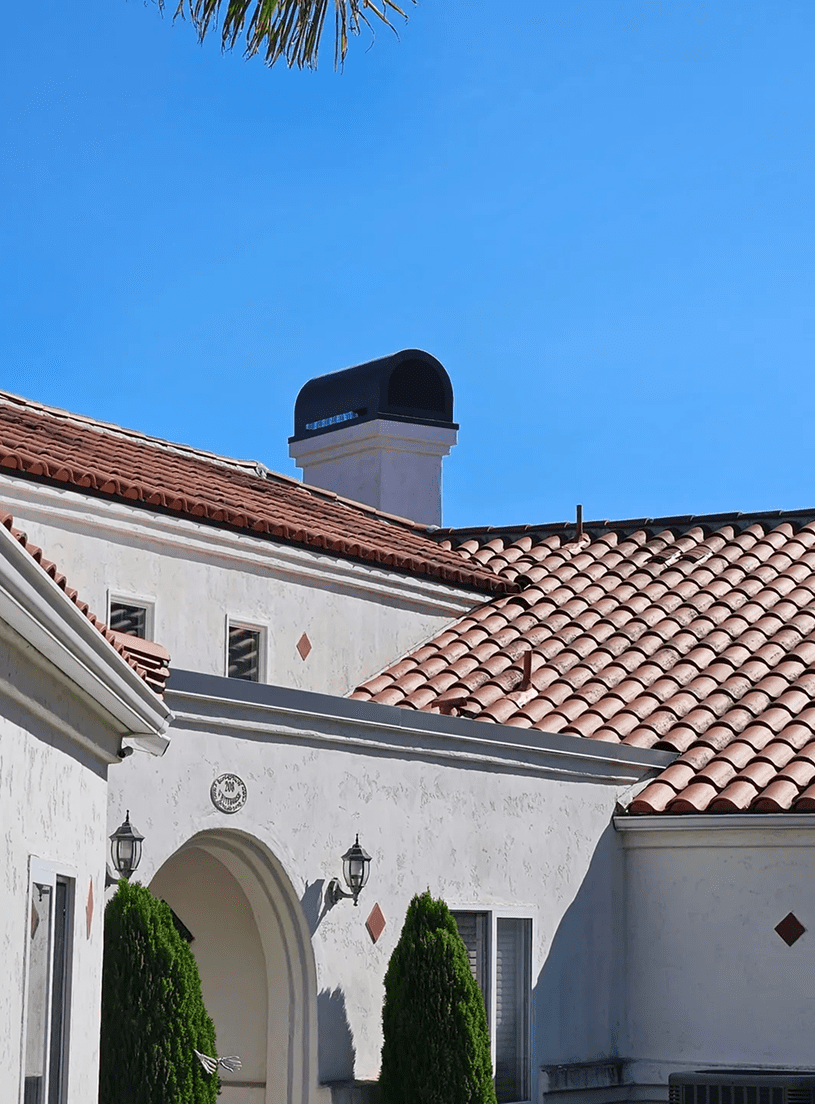House with terracotta roof under clear sky.